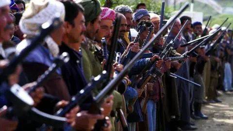 Getty Images Men holding guns, standing in a line