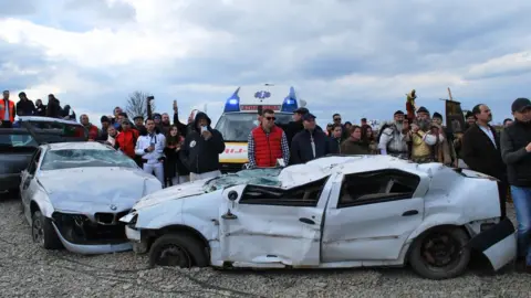 Two wrecked cars at the inauguration of the mini-motorway