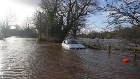 PA Media Car stranded in flood water at Warwick Bridge in Cumbria, 22 January