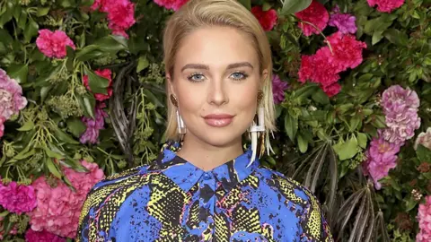 Getty Images Gabby Allen in front of some flowers