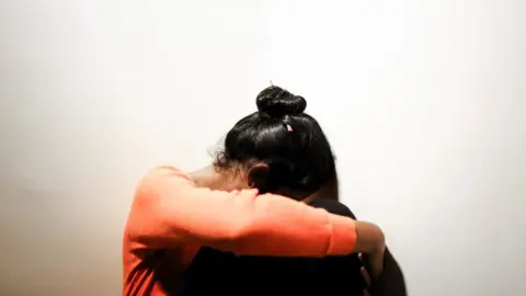 Getty Images Generic image of a woman with her head between her knees