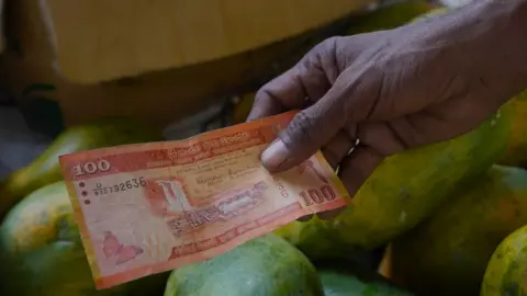 Getty Images A vendor deals in rupee notes on March 21, 2023, in Colombo, Sri Lanka.