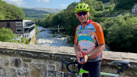 Family photograph Andy Fowell in cycling clothing with bike