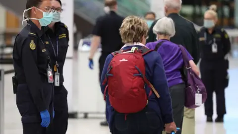 Getty Images Border officials and travellers at an Australian airport