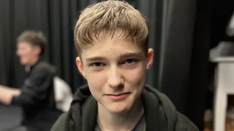 BBC 15-year-old Tom Hadfield-Doughty smiling at the camera wearing a black hoody
