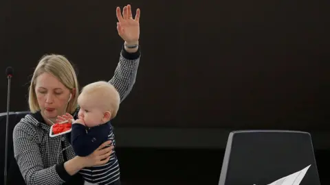 Reuters  Swedish Member European Parliament Jytte Guteland holds her baby as she takes part in a voting session at the European Parliament in Strasbourg, France.