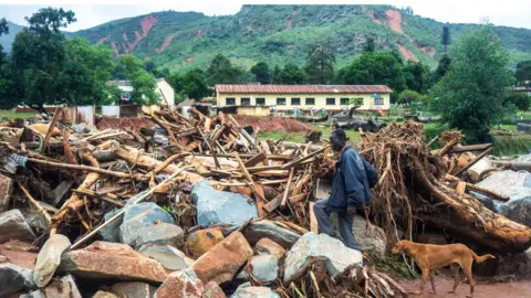 Getty Images A man searches the rubble for missing family members