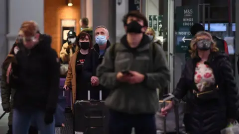 PA Media Travellers wait for trains on the concourse at King's Cross station in London