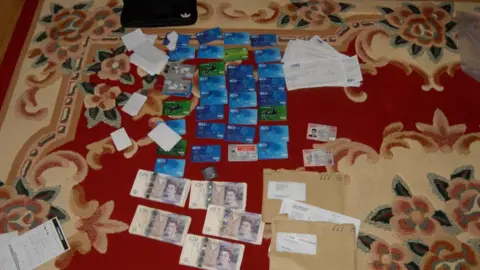 West Midlands Police Cash and bank cards laid out on the floor