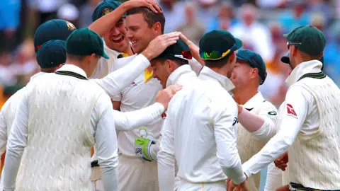 Australia players celebrate taking the wicket of England captain Joe Root during the second Test at Adelaide