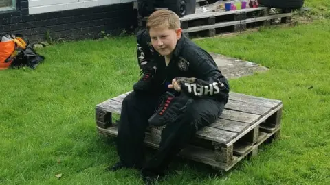 Kally Critchley Aston sat on a crate