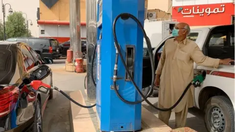 AFP Man filling his car at petrol station in Riyadh (file photo)