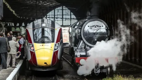 PA Media Flying Scotsman steam locomotive standing next to Azuma train