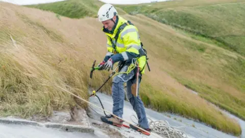 English Heritage Volunteer abseiling down White Horse
