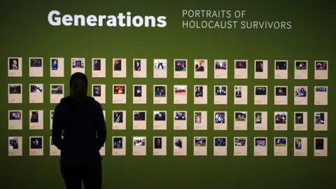 PA Media A person looks at the Generations portraits