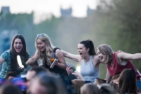 Reuters People react as they watch a screening of the concert marking Britain's King Charles' coronation, near Windsor Castle, Windsor, Britain May 7, 2023