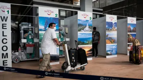 Getty Images International passengers receive covid-19 coronavirus swab testing at the testing booth after arriving Phuket International Airport