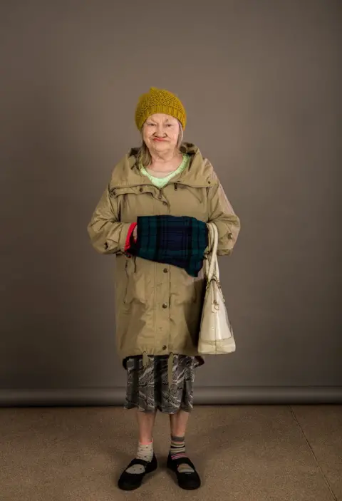 Dean Belcher An elderly lady wearing a woolly hat and coat