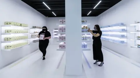 PA Media Amy Healey, and Alisha Moore, from Manchester work inside of a shop which is part of an art installation titled EART, by Rashid Rana