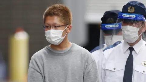 EPA Kyota Hattori (L), a 24-year-old suspect of a knife and arson attack on a Tokyo train, is taken to prosecutors on suspicion of attempted murder, in Tokyo, Japan, 02 November 2021.