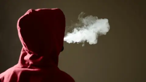 Getty Images Young man in a hoody vaping