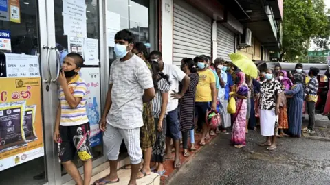 Getty Images Long queue seen outside a government-run supermarket in Colombo