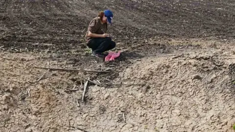 Royal Agricultural University Woman next to crater recording results