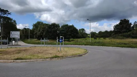 Daniel Mumby Half a roundabout with a field beyond