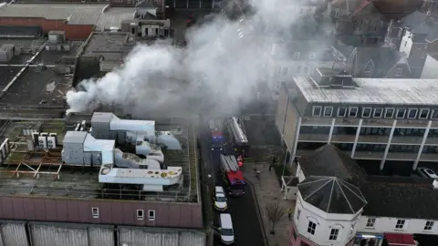 Smoke billowing from a warehouse.