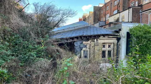 A building is partially destroyed by a landslip.
