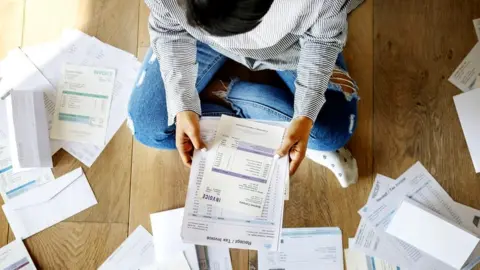 Getty Images Woman looking at bills