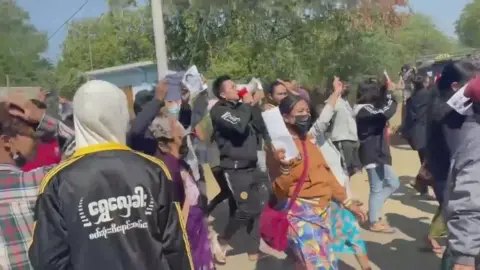 Yell Aung Shinn/Social Media People chant as they march along a street during a protest against the military coup in Mandalay, Myanmar February 9, 2021, in this still image obtained from a social media video.