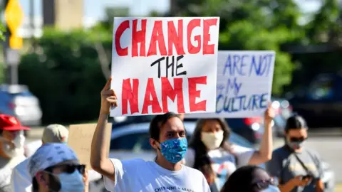 Getty Images Demonstrators call for the Cleveland Indians to change their name outside a game in July 2020