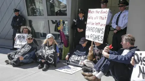 Getty Images People hold placards as they take part in a nuclear disarmament protest outside the United Nations (UN) headquarters in New York on April 28, 2015