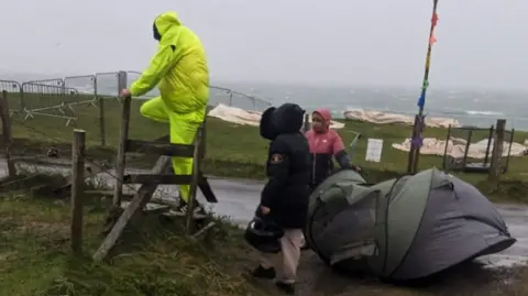 Festival-goers get help with tent in extreme weather