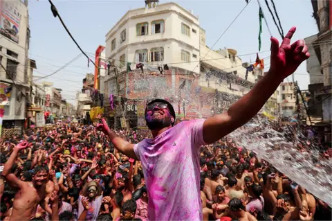 Getty Images People dance as they throw coloured powder and spray water during Holi celebrations, amid the COVID-19 pandemic, in Prayagraj, India's northern state of Uttar Pradesh on March 30, 2021.