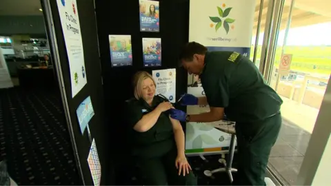One staff member vaccinating another in the East of England ambulance crew