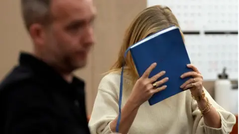 Getty Images At times Ms Paltrow attempted to hide from the cameras in court