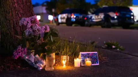 The Washington Post via Getty Images A small vigil across the street to the scene of a shooting at a Tops Friendly Market store in Buffalo, New York on 14 May