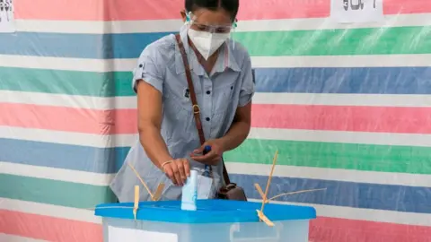 Getty Images A voter casts her ballot at a polling station in Yangon on November 8, 2020.