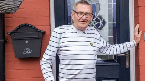 Elliot Nichol Photography a man in a striped top standing by a door