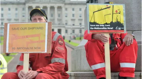 PAcemaker  workers sit on carson with placards