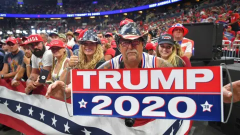 AFP A man holds up a sign as the crowd waits for US President Donald Trump to arrive at a rally at the Amway Center in Orlando