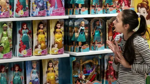 Getty Images A girl looking at Disney Princess dolls
