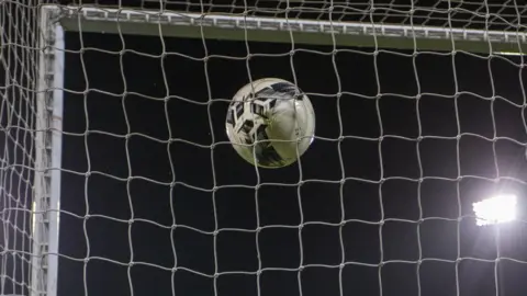 Getty Images A football goes into a net