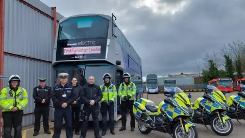 Norfolk Police Norfolk Police officers in front of a double-decker bus