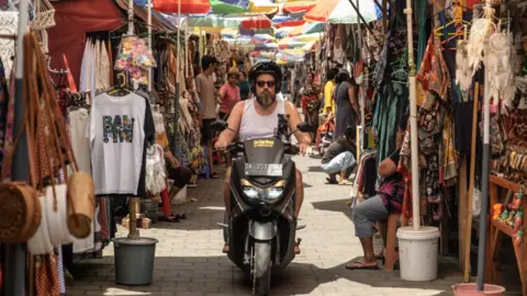 A foreign tourist riding a motorbike in Ubud, Bali