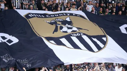 PA Media Notts County fans with a giant flag