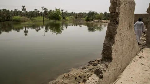 Getty Images A damaged building seen near a submerged area after flash floods hit Merove town of Khartoum, Sudan on 13 September 2020