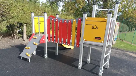 Broxtowe Borough Council Red and yellow playground equipment on rubber a surface at the Lane Recreation Ground, in Awsworth, Nottinghamshire.
